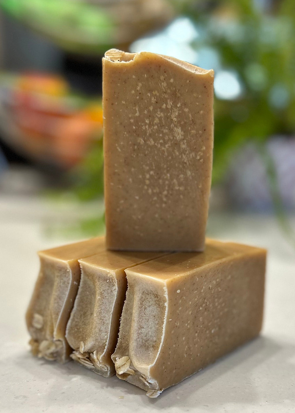 Stack of brown natural soap bars on a white surface with a blurred background