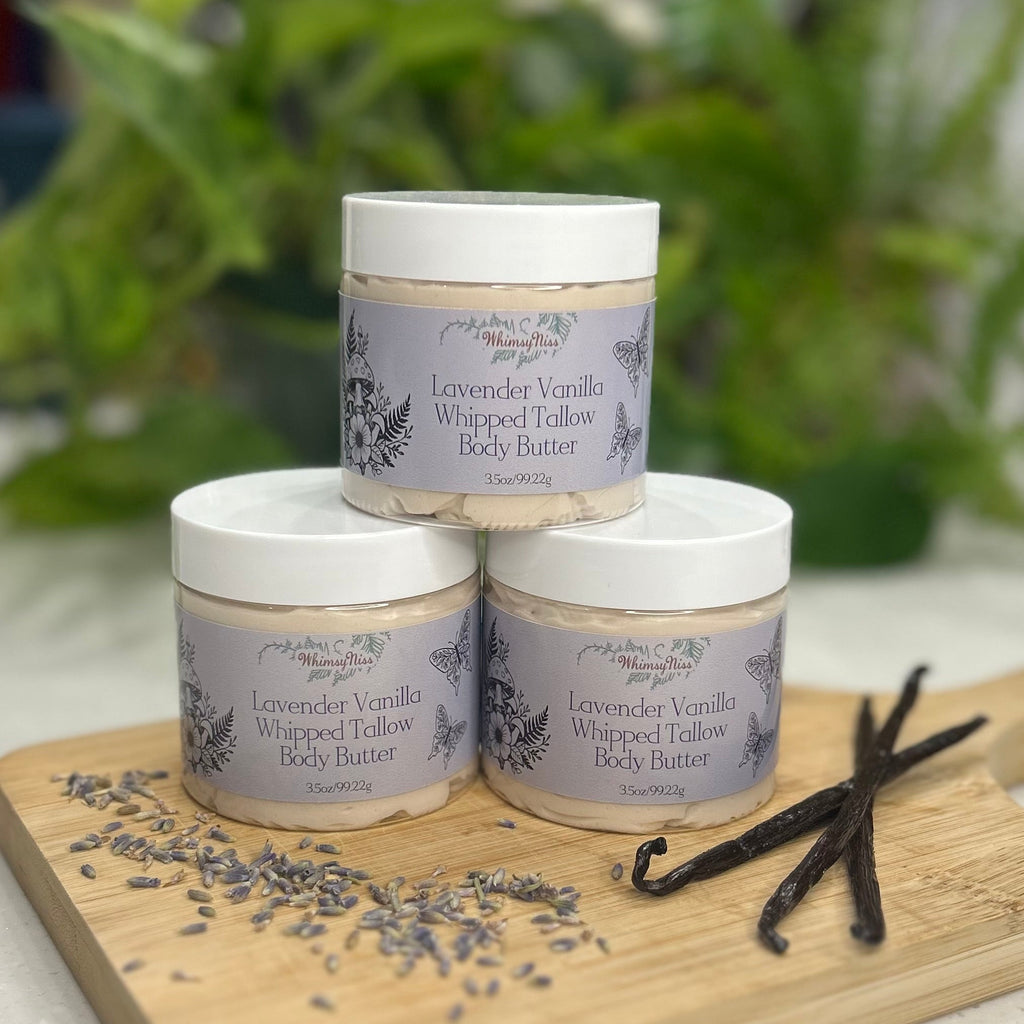 Three jars of Lavender Vanilla Whipped Tallow Body Butter on a wooden board with lavender and vanilla beans.