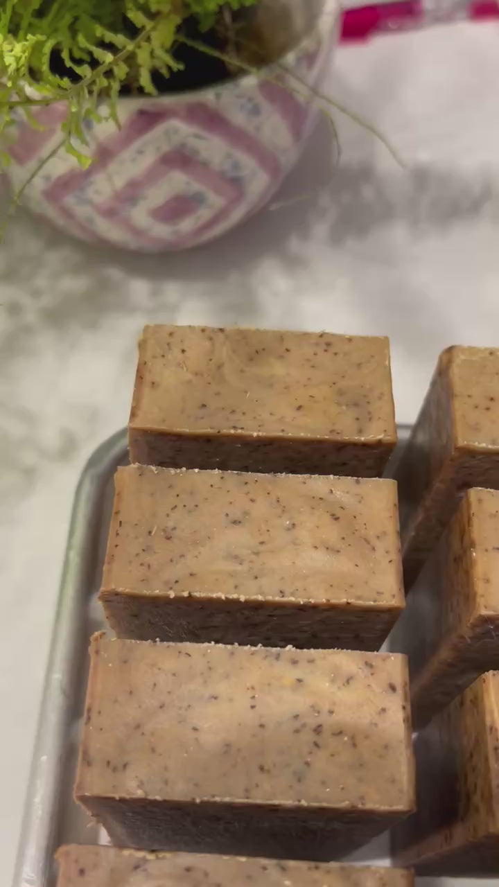 Video of cut bars of brown soap on a metal tray on top of a white counter.