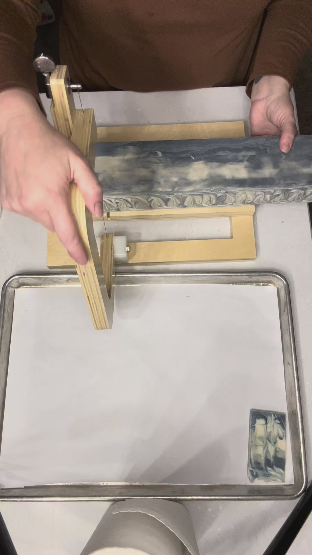 video of cutting up a blue swirled soap loaf in a white surface