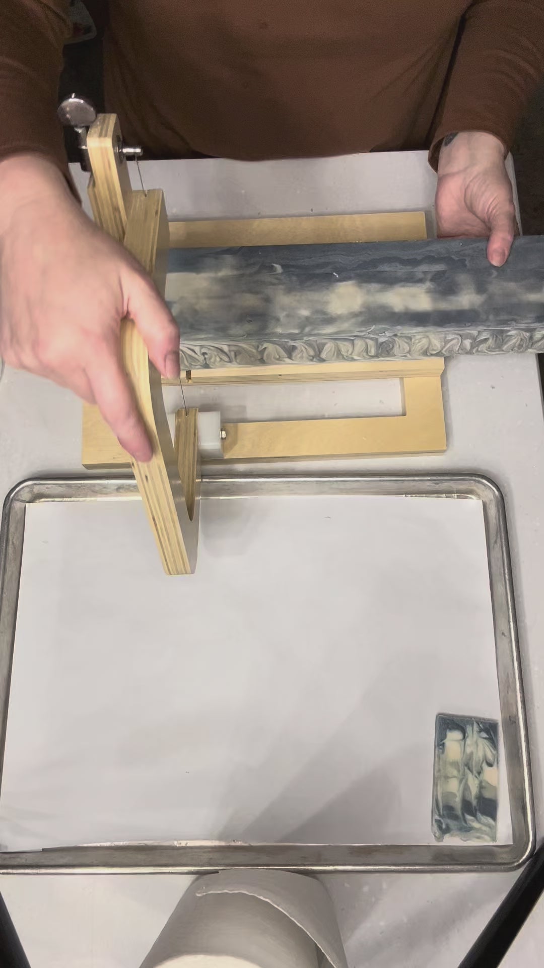 video of cutting up a blue swirled soap loaf in a white surface
